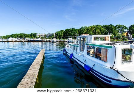Houseboats And Yachts Are Moored In Goehren-lebbin (germany) At A Jetty Of The Lake Fleesensee