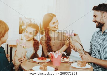 Father And Girls Celebrate Happy Day 8 March Holiday With Family. Good And Sweet Food. Flower And Fo
