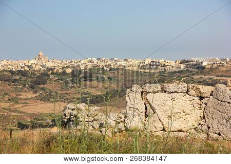 Panoramic View From Ggantija Temples To Town On Gozo Island, Malta In Sunny Day. Blurred Green Grass