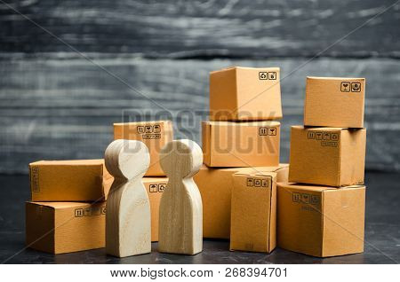 People Stand And Talk Near The Cardboard Boxes. Services For The Transportation And Delivery Of Good