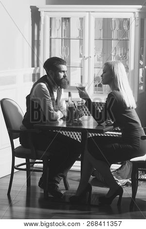 Woman And Man Dating In Restaurant. Girl With Blond Hair And Hipster Drinking Wine From Martini Glas