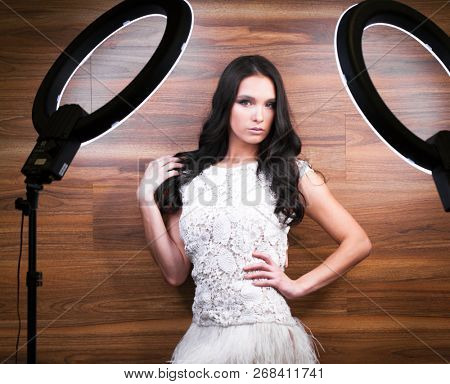 Studio portrait young woman in white dress with ring flash effect. Round LED Circle Lamp
