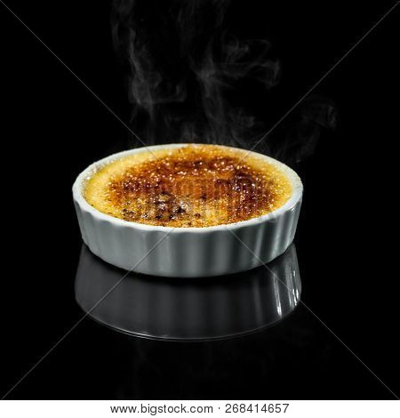 Close Up Of A Creme Brûlée With Smoke From The Burned Sugar Isolate Don A Black Background