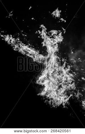 Black And What Close Up Detail Of Wildfire Flames Twisting Into Shapes Against Black Background.