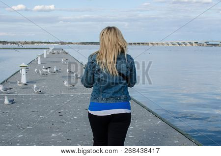 Young Adult Woman Walks Out Onto A Pier Near The Choptank River In Cambridge Maryland On A Sunny Spr