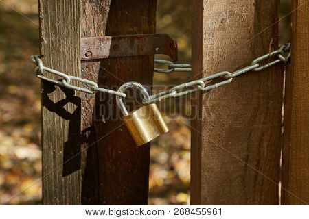 Wooden gate locked by a padlock and chain