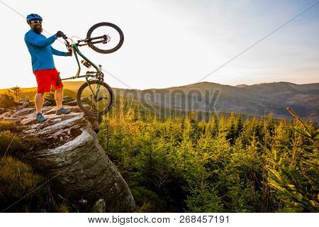 Mountain biker riding on bike in spring mountains forest landscape. Man cycling MTB enduro flow trail track. Outdoor sport activity.