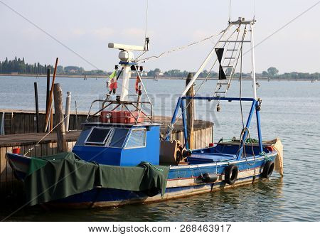 Small Blue Fishing Boat Moored In The Port Of An Island Near Venice