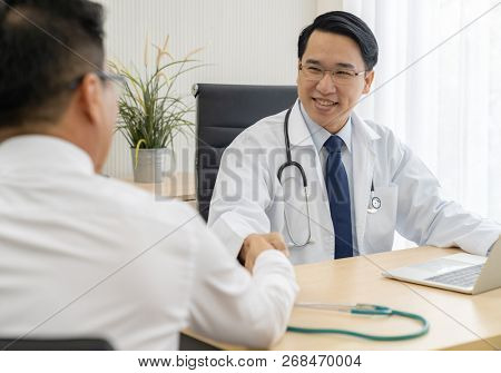 Portrait of Young adult Doctor with Patient in examination room medical office.