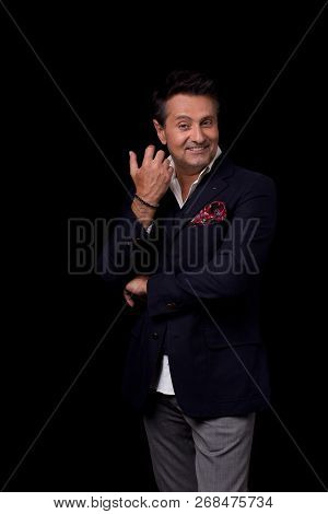 Emotional Middle Aged Man In Elegant Suit Standing Against The Black Background And Smiling Happily