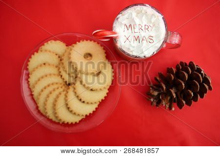 Hot Chocolate. Hot Coco in a glass mug with whip cream, cookies and text. Red Christmas background. Room for text