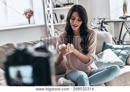Testing New Beauty Product. Beautiful Young Woman Testing Beauty Product And Smiling While Making So