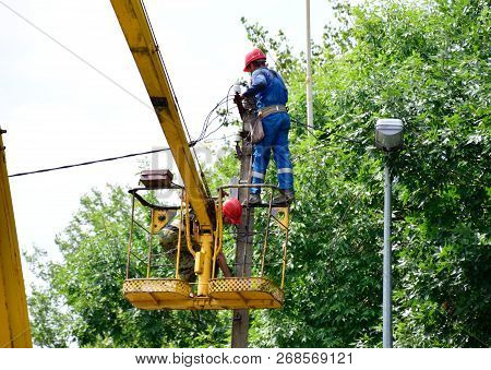 Krasnodar, Russia - August 06, 2018: Electricians Repair The Wires On The Pole With The Help Of A Cr
