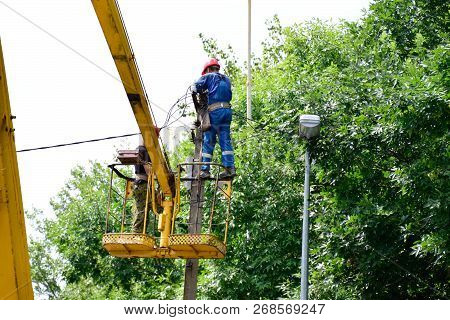 Krasnodar, Russia - August 06, 2018: Electricians Repair The Wires On The Pole With The Help Of A Cr