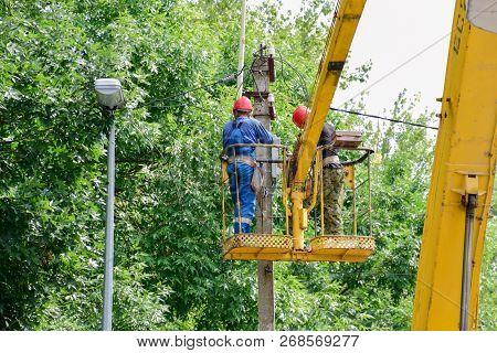 Krasnodar, Russia - August 06, 2018: Electricians Repair The Wires On The Pole With The Help Of A Cr