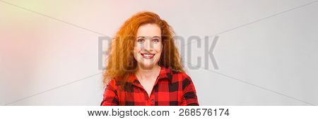 Young Red-haired Girl In A Red Checkered Shirt. Young Girl Spread Her Arms