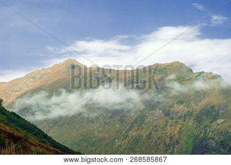 Landscape Of The Caucasian Highlands With A Cloud On A Hillside