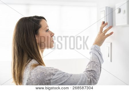 A Woman Set The Thermostat At House