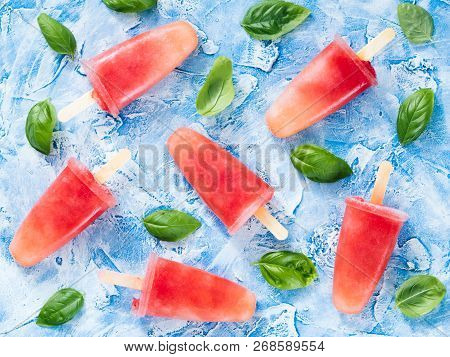 Top View Of Watermelon And Basil Popsicles On Blue Background With Fresh Green Basil Leaves. Summer 