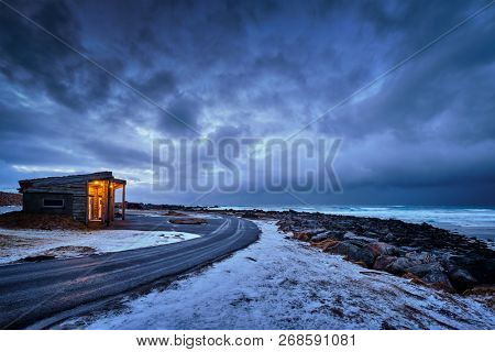 Shack on coast of Norwegian sea in fjord. Skagsanden beach, Flakstad, Lofoten islands, Norway in stormy evening