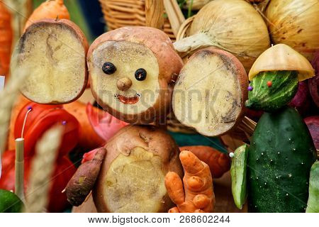 Farmers-made Cheburashka And Crocodile From Potatoes And Cucumbers. Showing The Autumn Harvest At Th