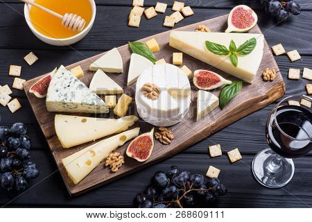 Cheeseboard With Cheese Brie , Parmesan , Camembert And Dorblu . Food On Wooden Board