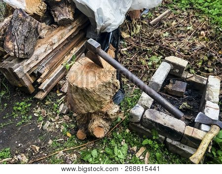 A Metal Hammer Sticks Out Of A Stump. Firewood Preparation.