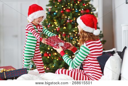 Happy Family Mother Hug Her Baby Son  In Pajamas  Opening Gifts On Christmas Morning Near Christmas 