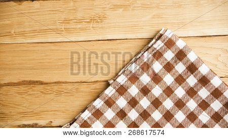 Checkered White And Rown Fabric On A Wooden Background