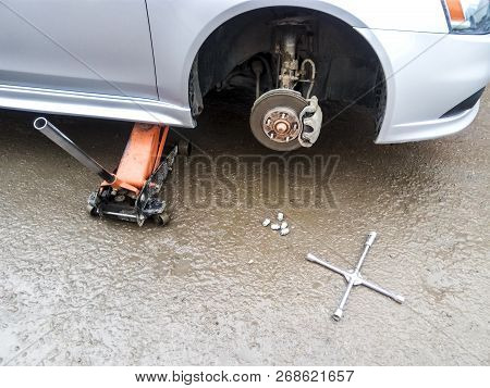 The Car Is At The Tire Shop. Under The Jack The Car In Car-care Center. The Car With The Removed Whe