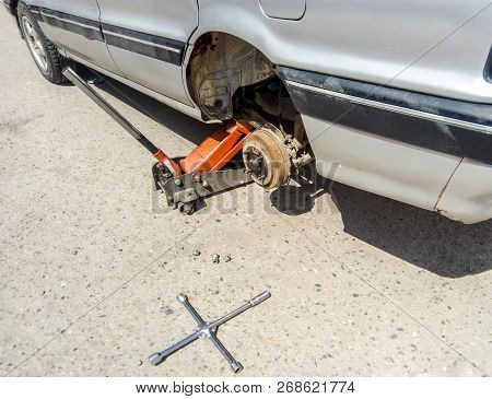 The Car Is At The Tire Shop. Under The Jack The Car In Car-care Center. The Car With The Removed Whe