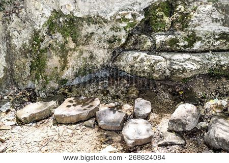 Water Flowing From The Stone. A Stream Running Along The Rocks