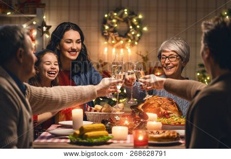 Merry Christmas! Happy family are having dinner at home. Celebration holiday and togetherness near tree.