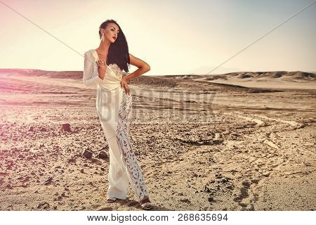 Elegance And Fashion Model. Bride And Wedding Ceremony. Woman In White Dress In Sand Dunes. Wedding 