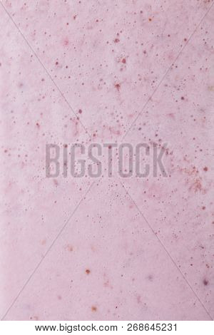 Macro photo of useful milky berry smoothie in transparent glass. Food layout.