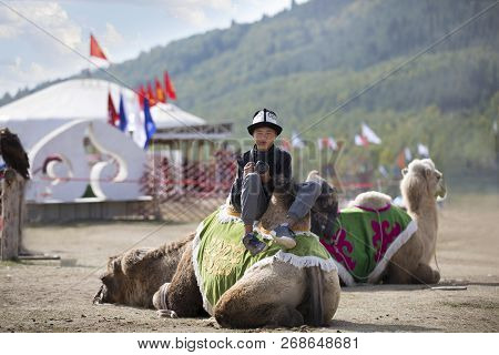Kyrchyn, Kyrgyzstan, 6th September 2018: Young Photographer Sitting On A Camel And Resting
