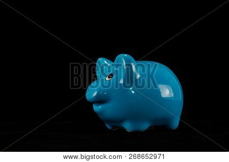 Blue Piggy Bank Or Money Box Isolated On A Black Studio Background