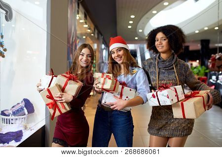 Three Mixed Race Women With Gift Boxes In Hands Near Storewindow. Multi Ethnic Girls Smiling With Pr