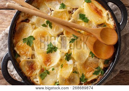 Janssonin Kiusaus Baked Potato With Anchovy Fillets, Onions And Heavy Cream Close-up In A Frying Pan
