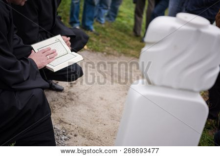 quran holy book reading by imam  on islamic funeral with white thumb stones graweyard background