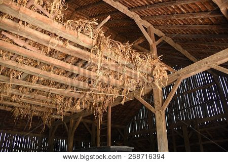 Looking Up At The Hayloft Of An Old Wooden Barn With Support Beams And Ceiling In The Background