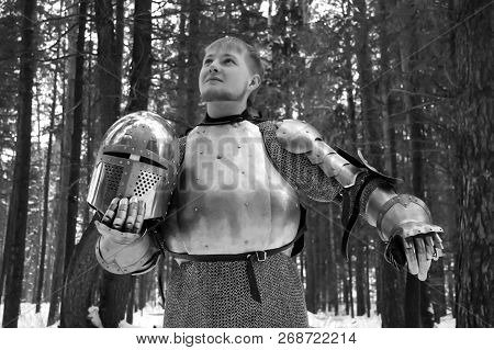 Knight In Armor And With A Sword In The Middle Of A Winter Forest. Vintage Military Uniform.