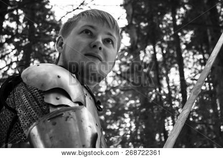 Knight In Armor And With A Sword In The Middle Of A Winter Forest. Vintage Military Uniform.
