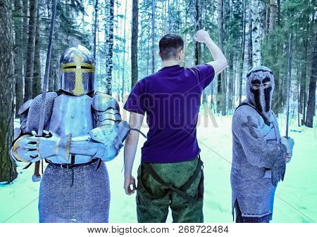 Knights In Armor, Mail And A Sword In The Middle Of The Winter Forest. The Guy In The Shirt Between 