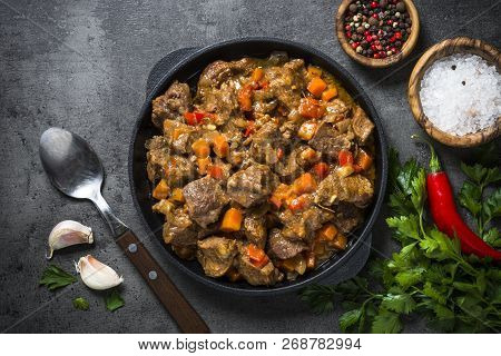 Beef Stew With Vegetables In Iron Pan On Black Background. European Cuisine. Top View.