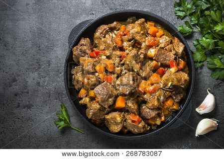 Beef Stew With Vegetables In Iron Pan On Black Background. European Cuisine. Top View.