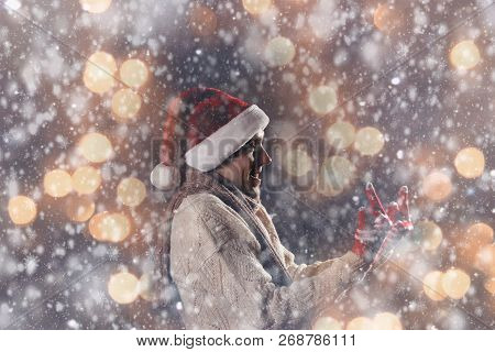 Christmas Gift Concept. Man In Santa Hat Bring Gift For You. Attractive Man Hold Box.  Christmas And