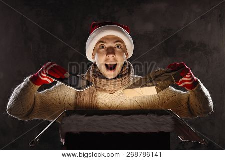 Christmas Gift Concept. Man In Santa Hat Bring Gift For You. Attractive Man Hold Box.  Christmas And