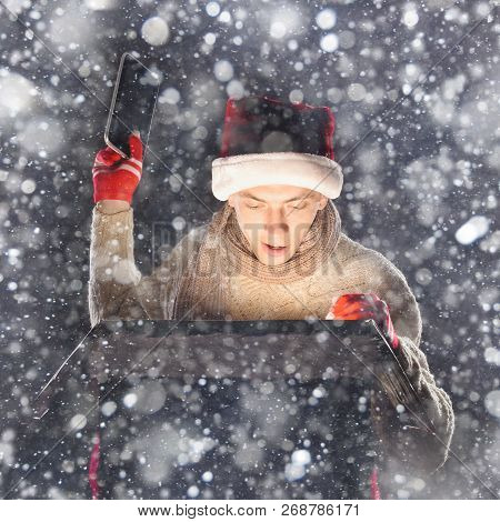 Christmas Gift Concept. Man In Santa Hat Bring Gift For You. Attractive Man Hold Box.  Christmas And