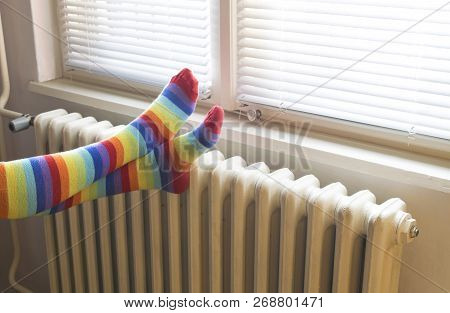 Heavy Duty Radiator - Central Heating. Woman With Colorful Socks Enjoying Winter In Warm, Cozy Room